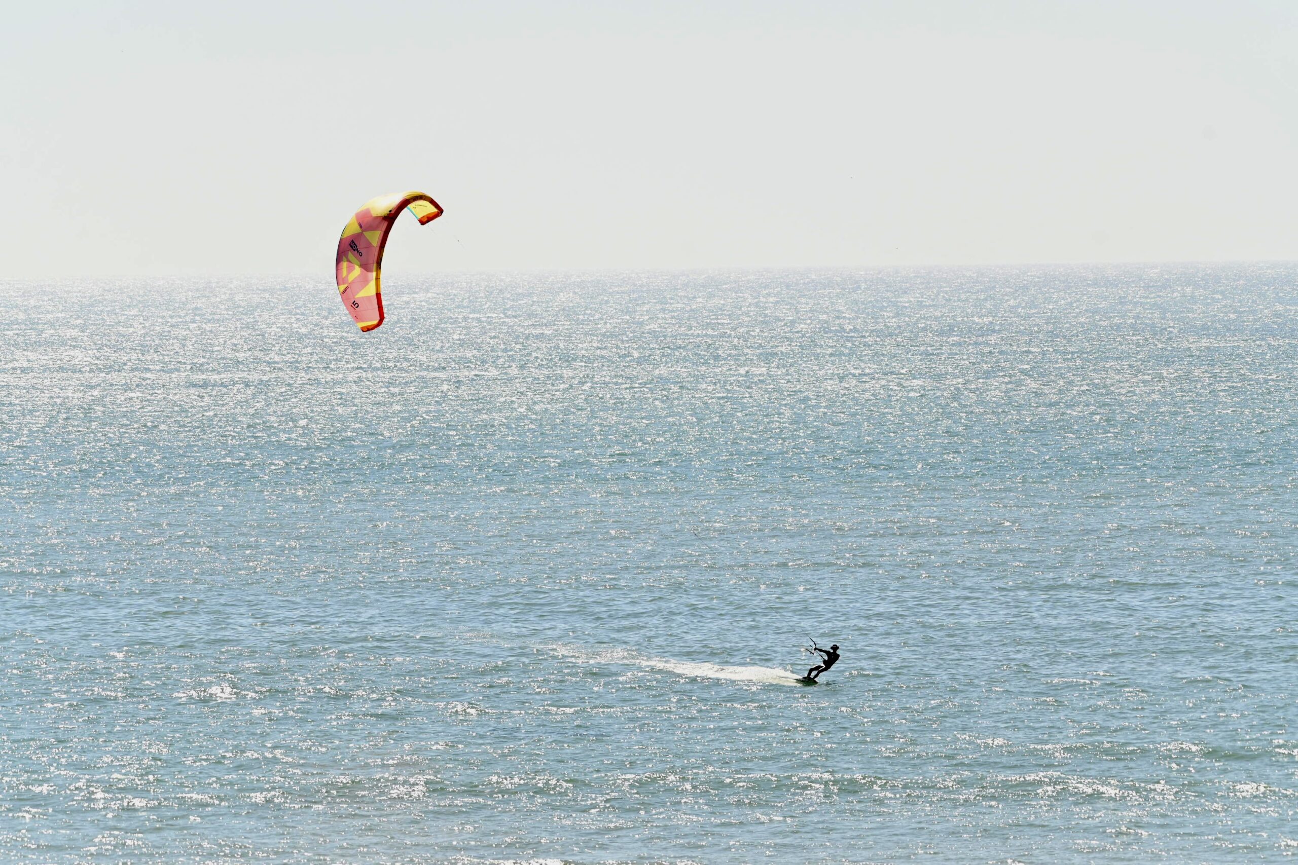 Kitesurf Essaouira | kitesurfeur filant sur l'eau avec un kite orange