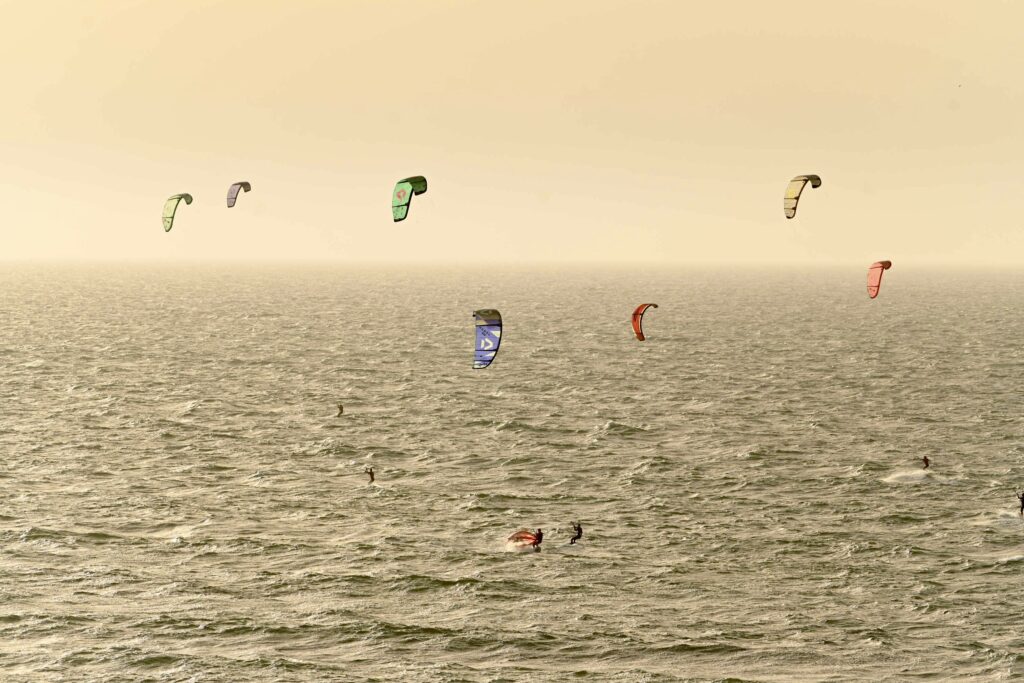 Ailes dans la lumière dorée du soir sur la baie d'Essaouira apprendre le wingfoil | flotte d’ailes dans la lumière dorée du soir sur la baie | 2