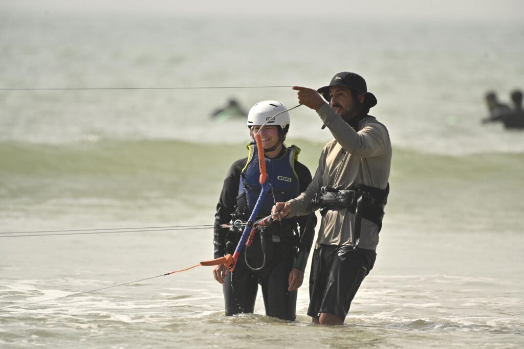 Moniteur donnant ses consignes à un élève dans l’eau à Essaouira cours de wingfoil | moniteur montrant la direction à l’élève dans l’eau | 2