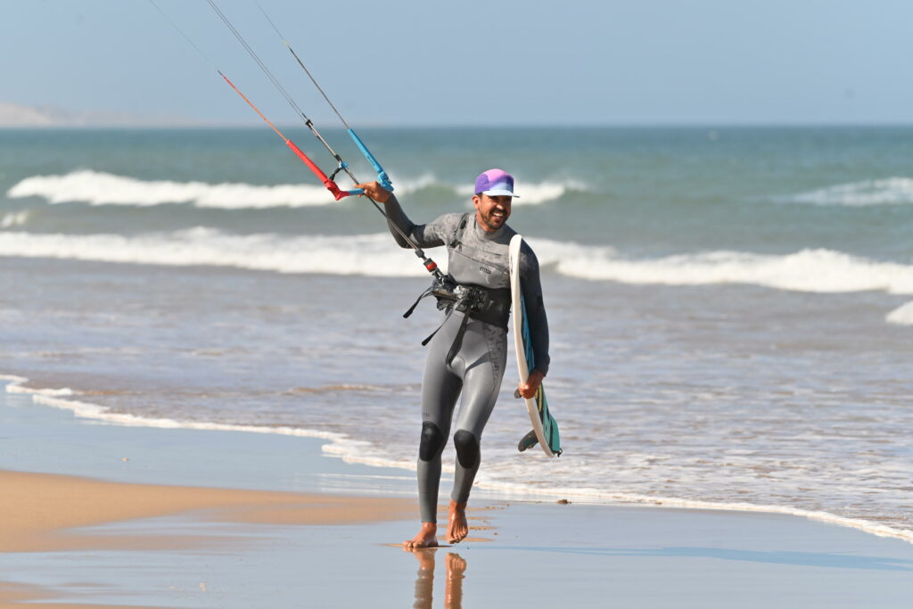 Kitesurfeur sortant de l’eau après la session à Essaouira surf camp essaouira | kitesurfeur sortant de l’eau avec sa barre après la session | 4