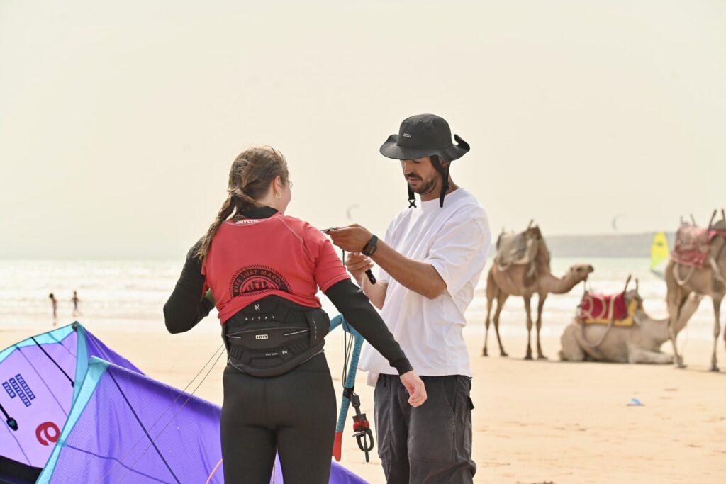 cours de surf maroc | moniteur et élève sur la plage avec des chameaux à Essaouira | 4